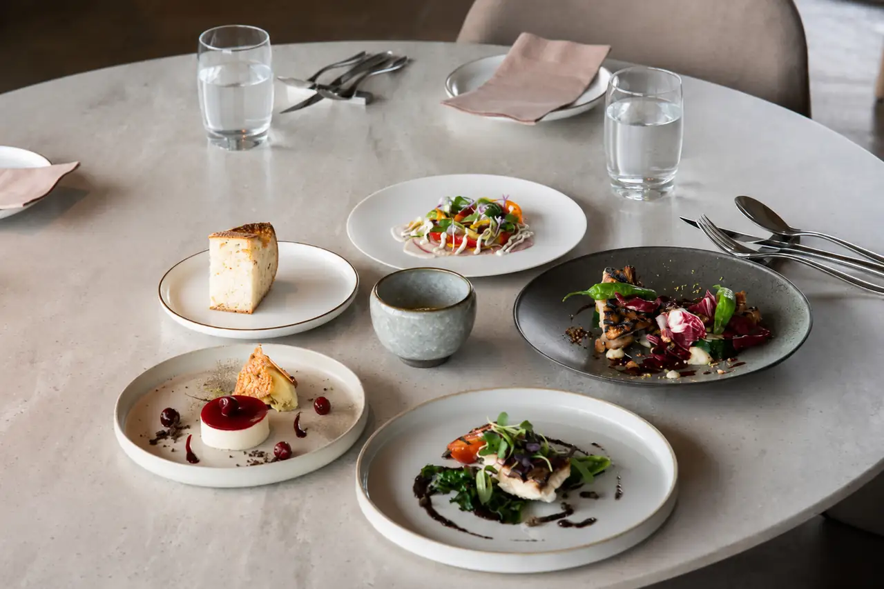 Exquisitely set private dining table with fine glassware and seasonal floral arrangements