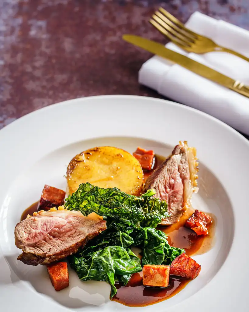 Expertly plated roast lamb with seasonal vegetables
